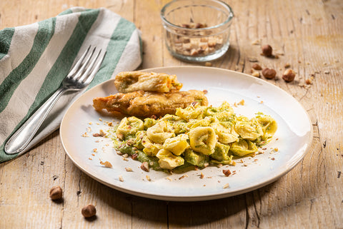 Cappelletti al “Prosciutto di Parma DOP” con crema di zucchine e fiori di zucca croccanti e nocciole