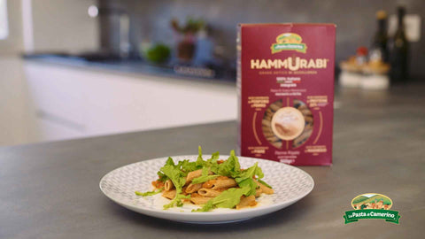 confezione e piatto di penne Hammurabi con crema all'aglio, polpa di pomodoro e insalata di rucola fresca